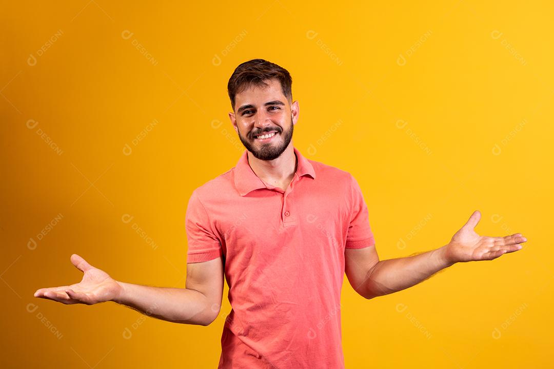 homem bonito sorrindo braços abertos sobre fundo amarelo