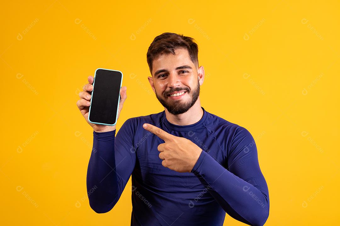 homem bonito com celular nas mãos apontando