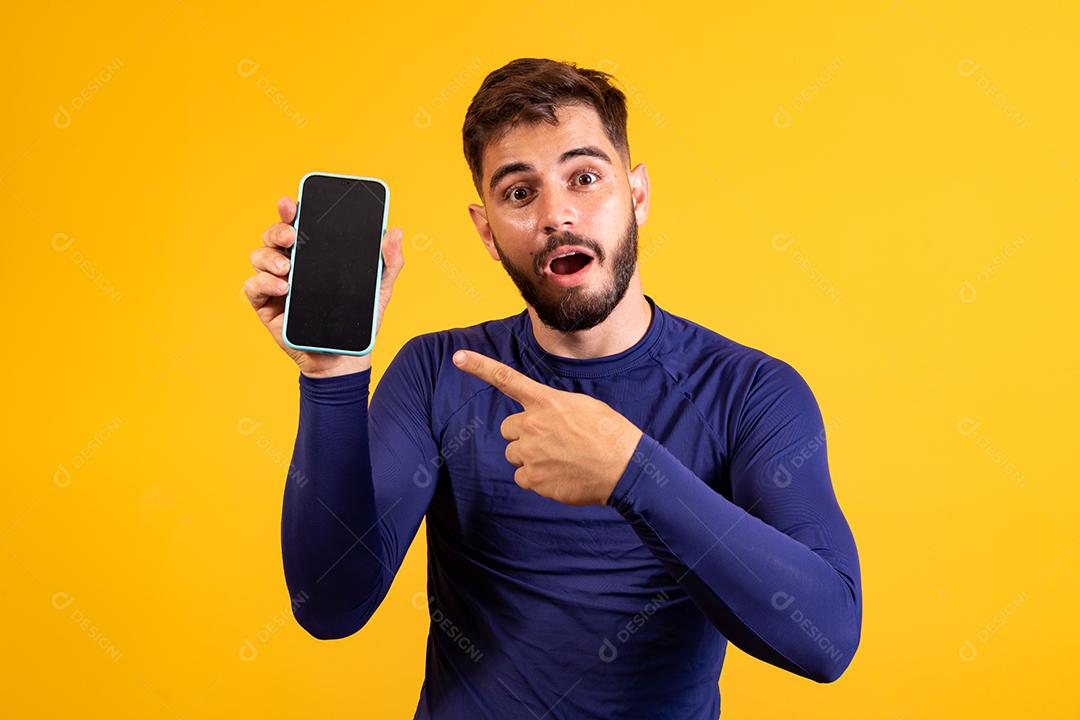 homem bonito com celular nas mãos apontando