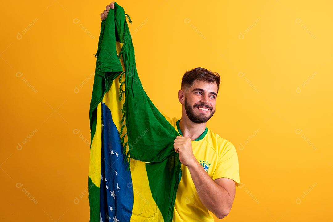 fã de homem segurando um fundo amarelo de bandeira brasileira. Cores do Brasil ao fundo, verde, azul e amarelo. Eleições, futebol ou política.