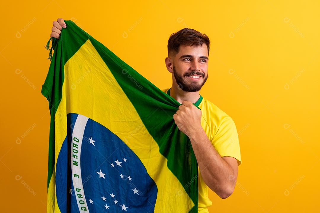fã de homem segurando um fundo amarelo de bandeira brasileira. Cores do Brasil ao fundo, verde, azul e amarelo. Eleições, futebol ou política.