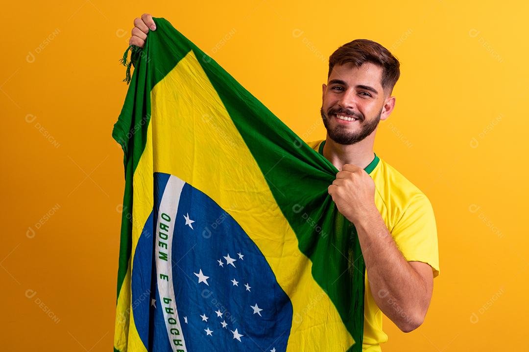 fã de homem segurando um fundo amarelo de bandeira brasileira. Cores do Brasil ao fundo, verde, azul e amarelo. Eleições, futebol ou política.