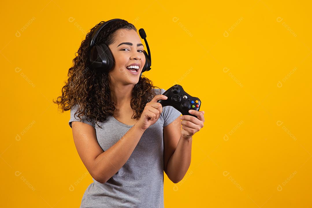 Mulher excitada jogando videogame em fundo amarelo