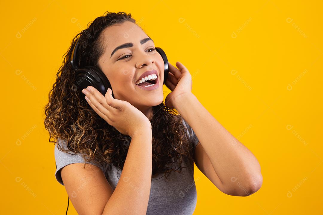 jovem afro com seus fones de ouvido ouvindo música.