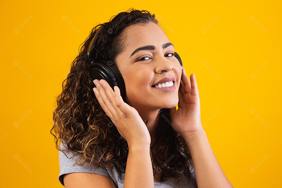 jovem afro com seus fones de ouvido ouvindo música.