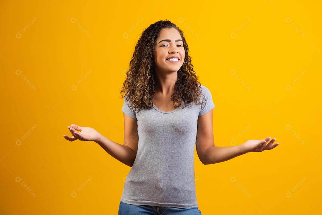 jovem afro sorrindo em fundo amarelo com espaço livre