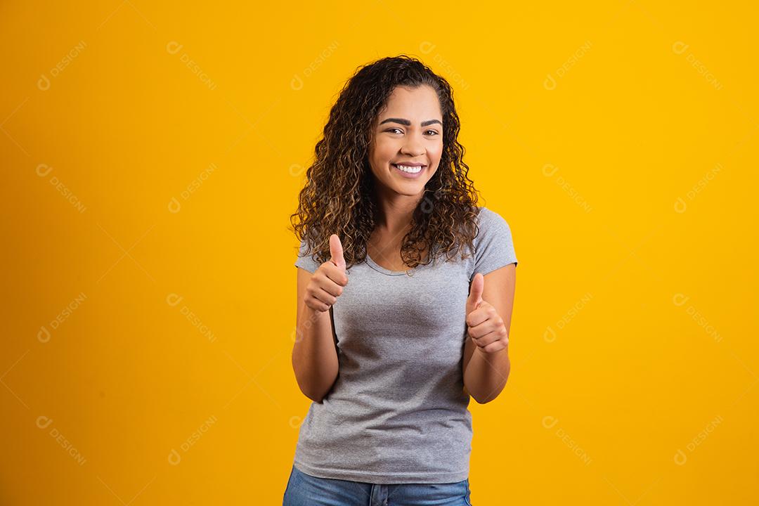 Retrato de sorrir bela jovem afro polegares para cima. brasileiro
