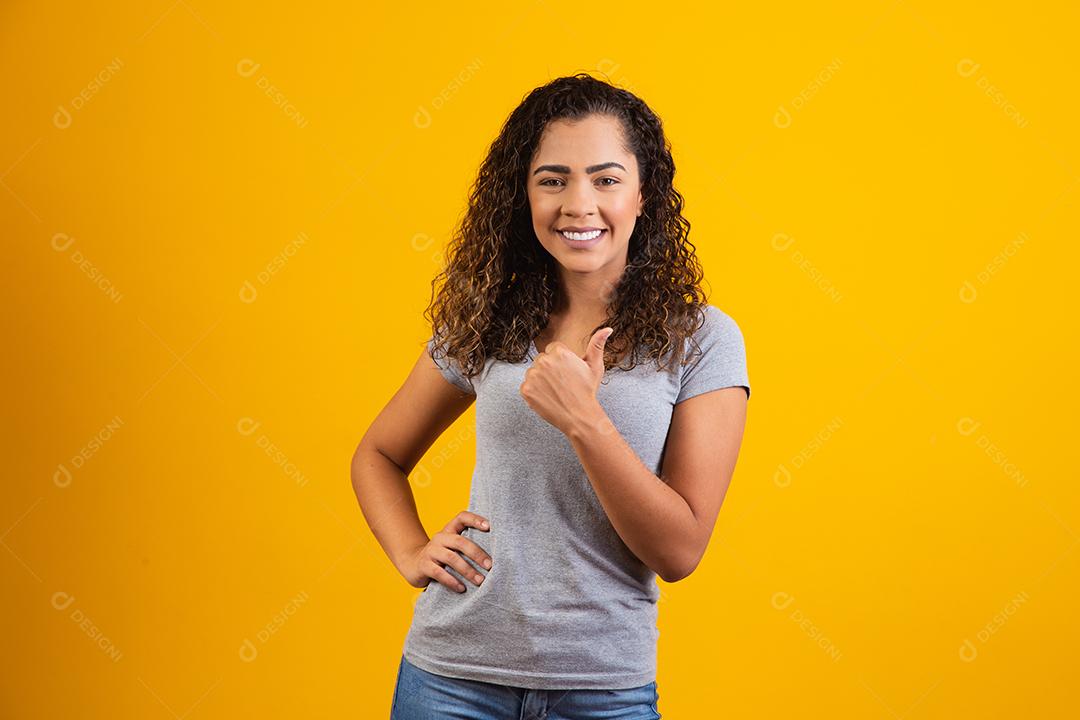 Retrato de sorrir bela jovem afro polegares para cima. brasileiro