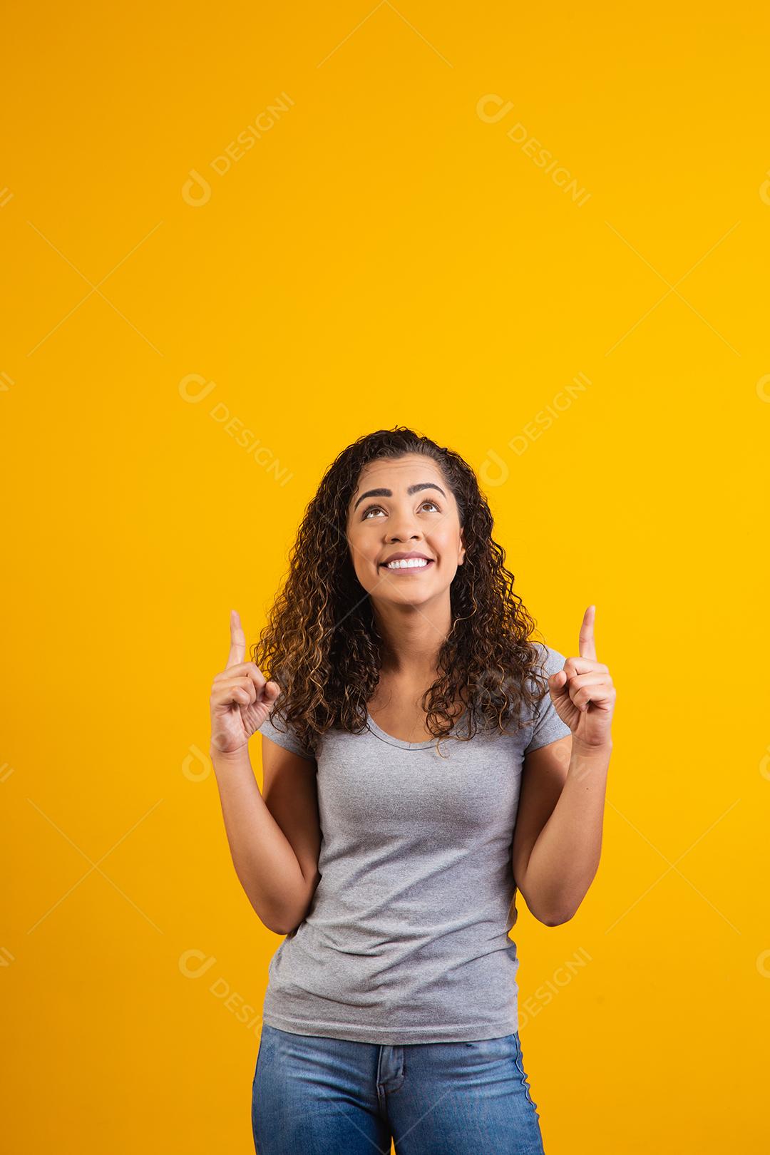 Mulher afro apontando em fundo amarelo com espaço para o texto