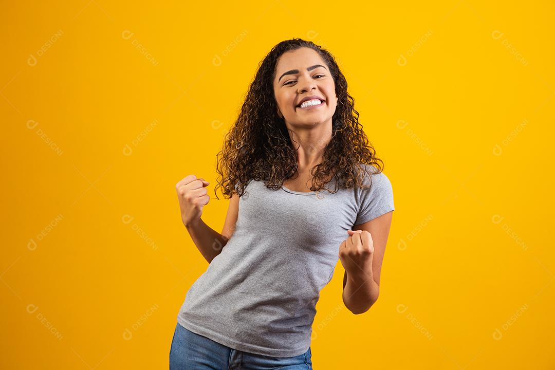 Jovem linda morena de cabelos cacheados regozijando-se alegremente dizendo