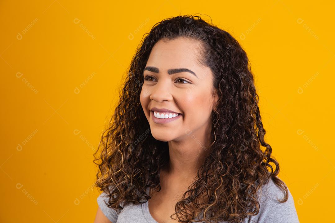 closeup no rosto de mulher afro sorrindo em fundo amarelo