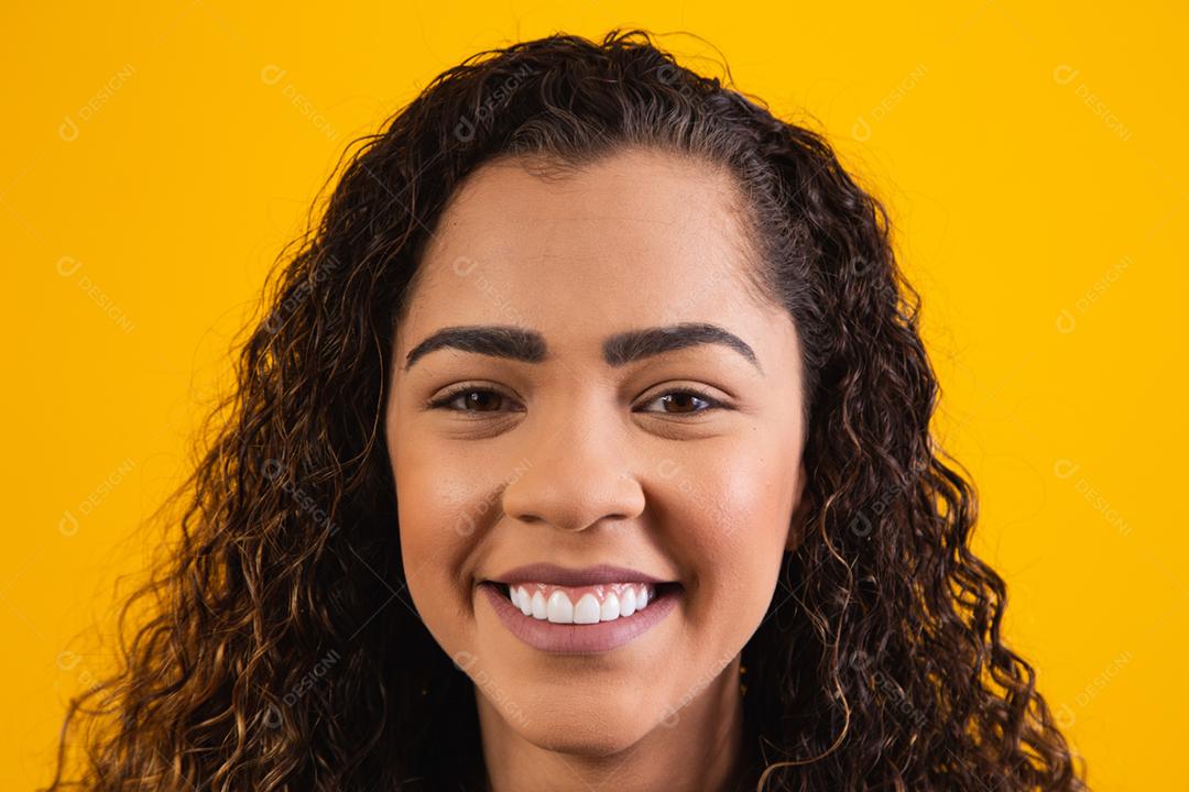 closeup no rosto de mulher afro sorrindo em fundo amarelo