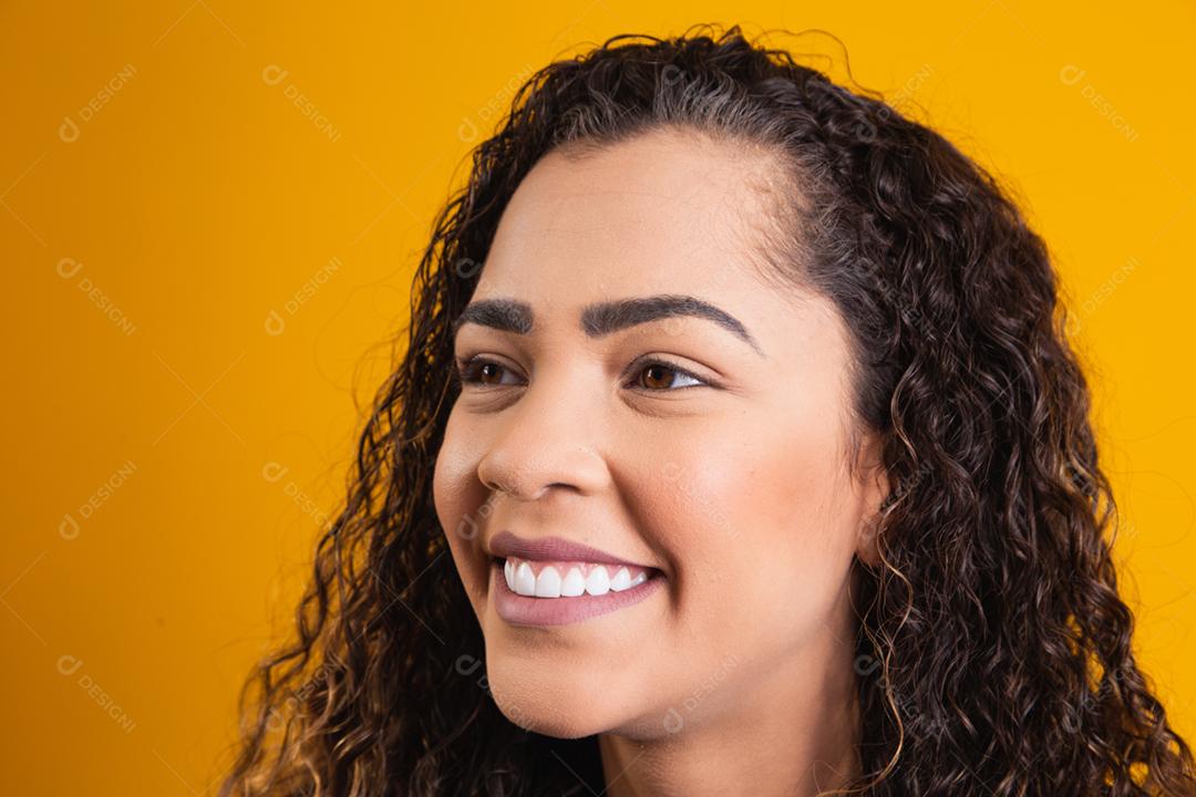 closeup on face of afro woman smiling on yellow background
