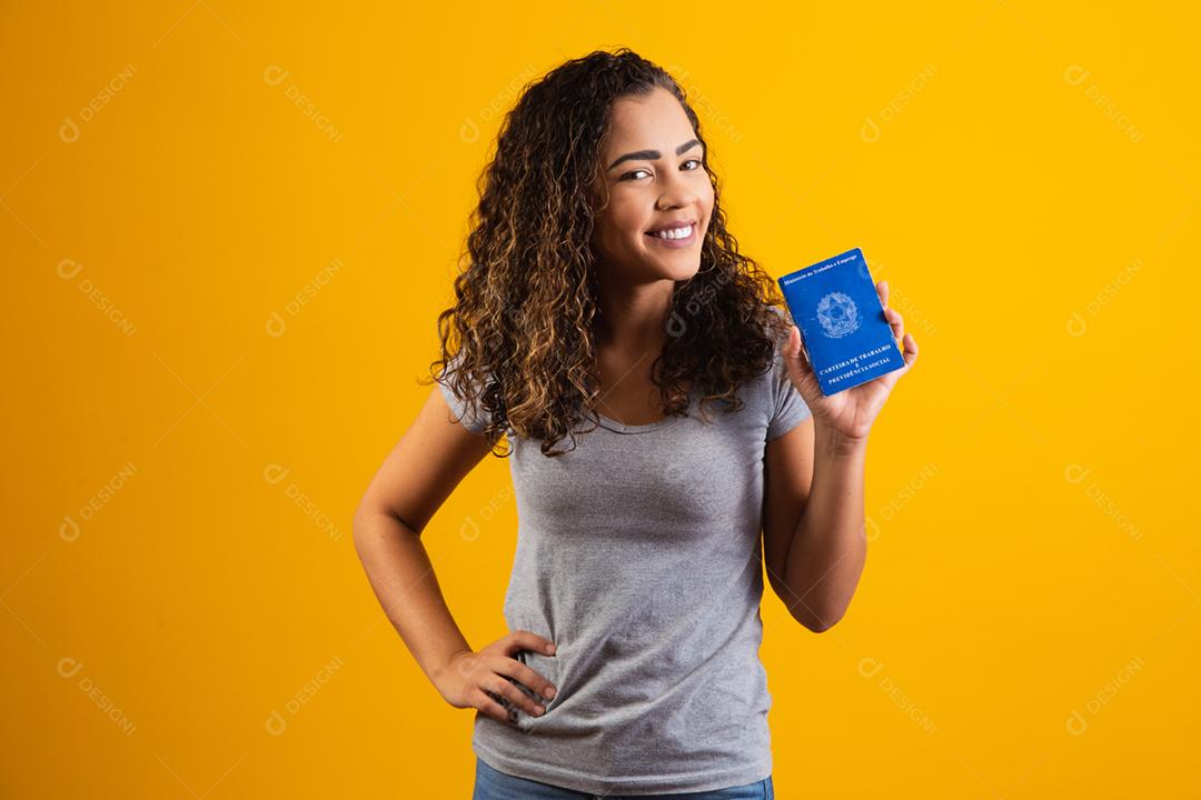 Mulher brasileira segurando uma carteira de trabalho
