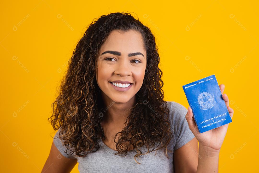 Mulher brasileira segurando uma carteira de trabalho