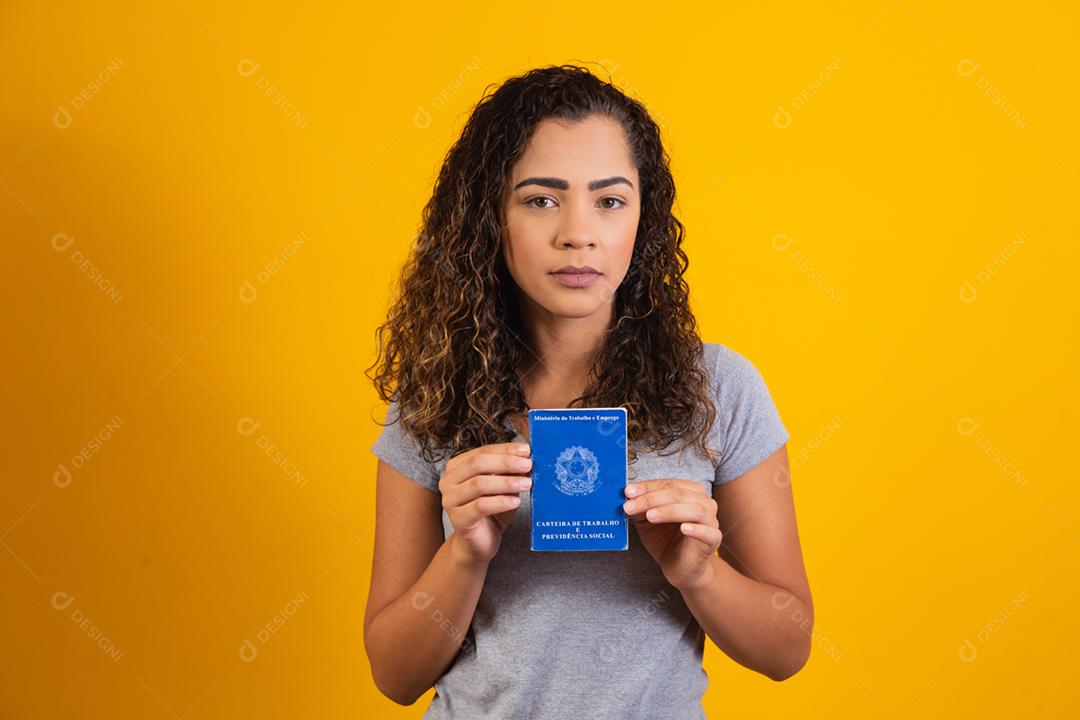 Mulher brasileira segurando uma carteira de trabalho
