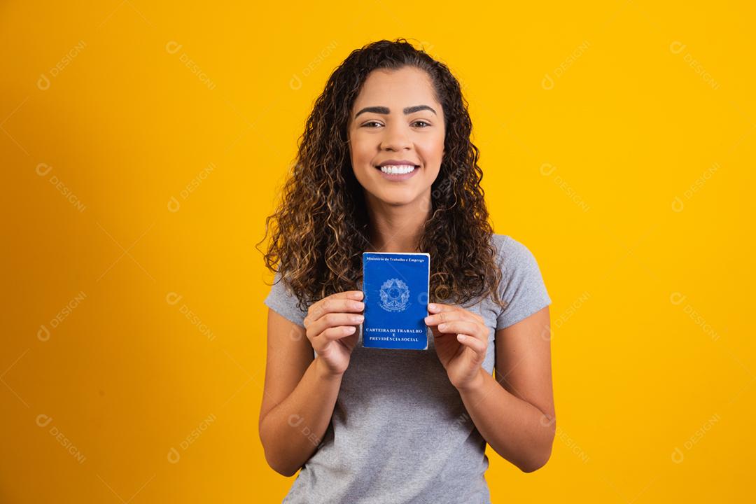Mulher brasileira segurando uma carteira de trabalho