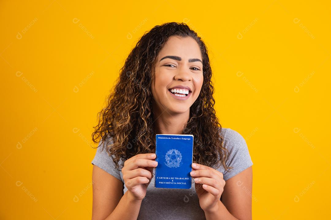 Mulher brasileira segurando uma carteira de trabalho