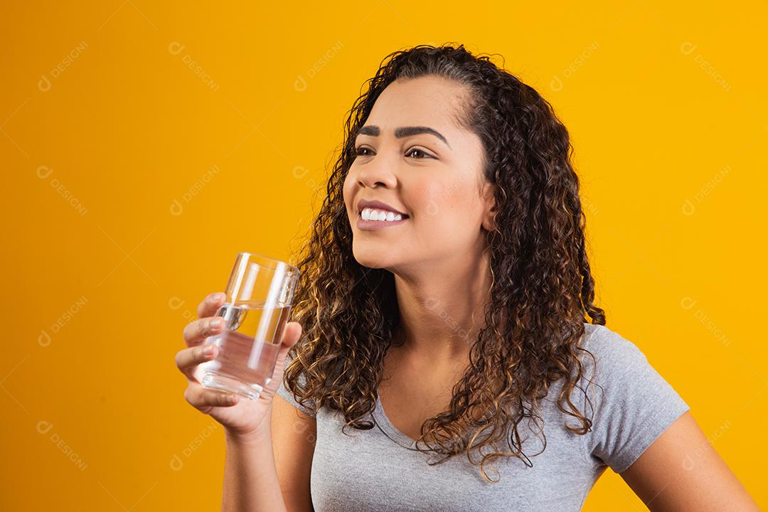 Mulher jovem e bonita bebendo um copo de água fresca