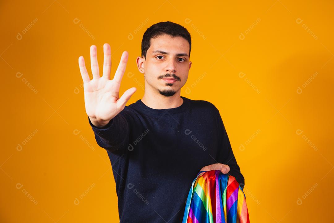 Orgulho gay. Garoto homossexual segurando bandeira lgbt em fundo amarelo