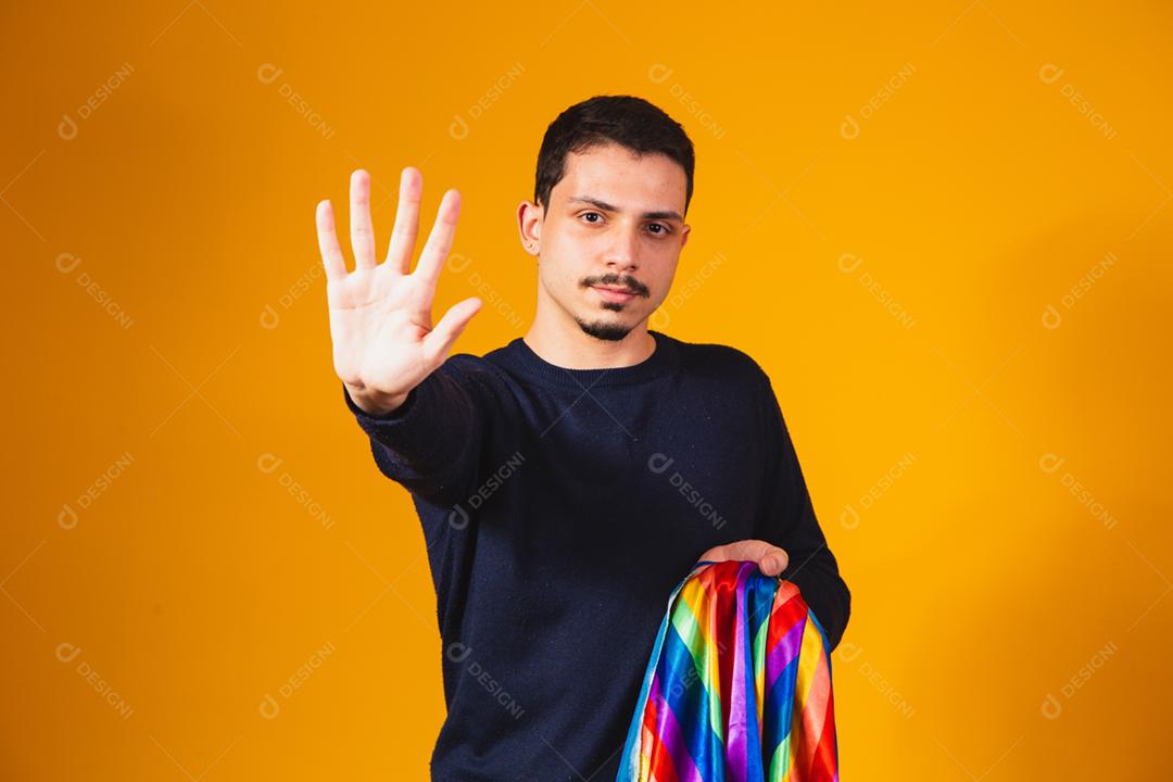 Orgulho gay. Garoto homossexual segurando bandeira lgbt em fundo amarelo