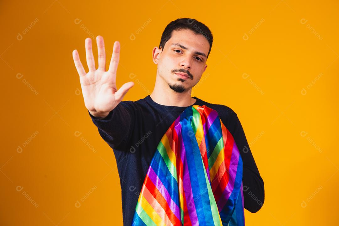 Orgulho gay. Garoto homossexual segurando bandeira lgbt em fundo amarelo
