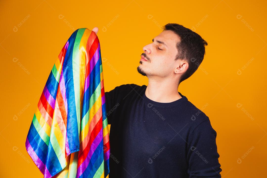 Orgulho gay. Garoto homossexual segurando bandeira lgbt em fundo amarelo