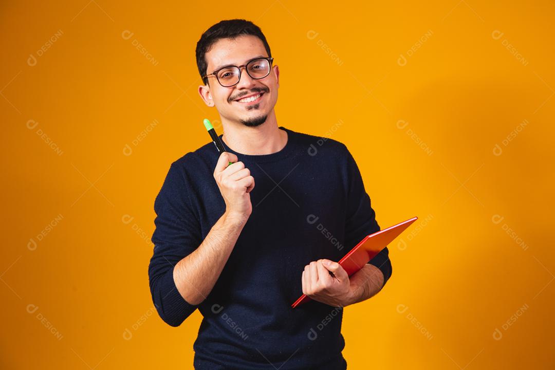 Retrato de estudante pensando e segurando o notebook em amarelo