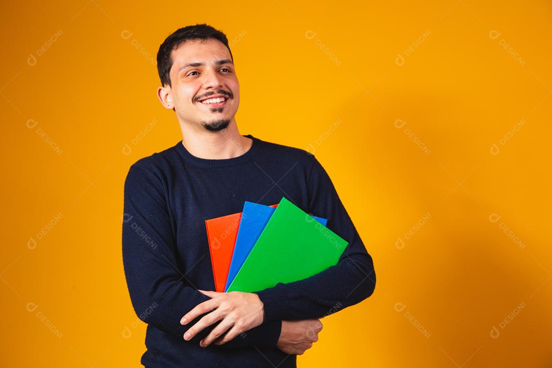Menino jovem estudante sobre fundo amarelo.