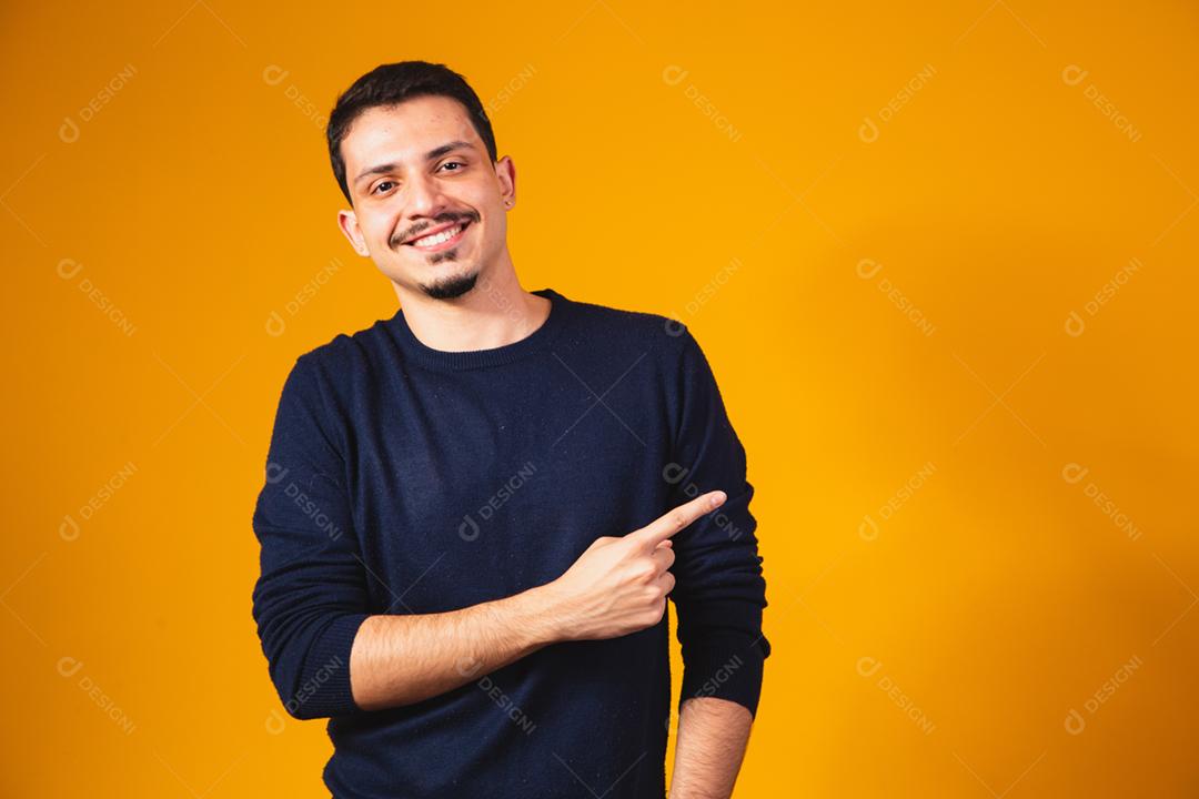 Animado rapaz apontando para espaço livre para texto.