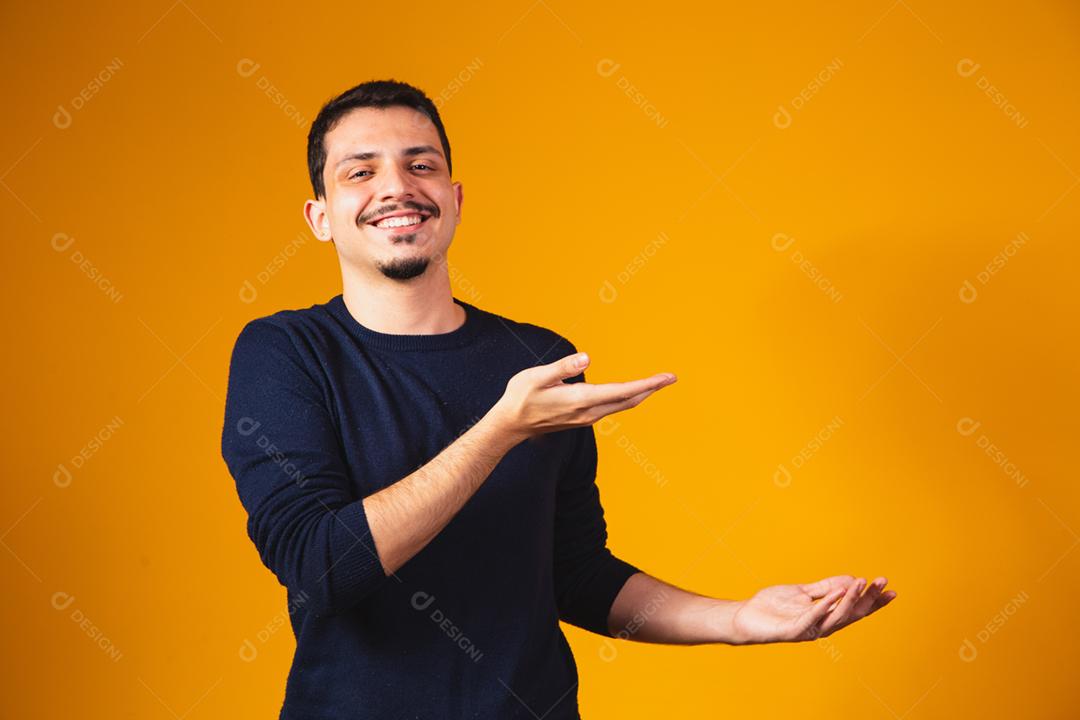 Animado rapaz apontando para espaço livre para texto.