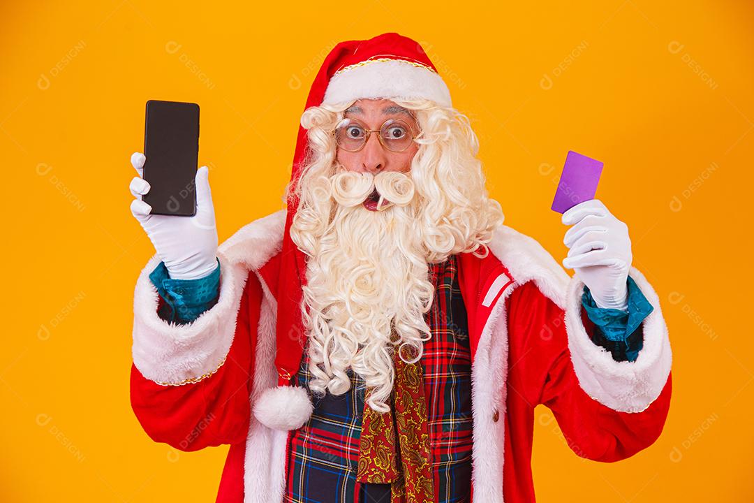 Papai Noel usando cartão de crédito para pagar compras na internet