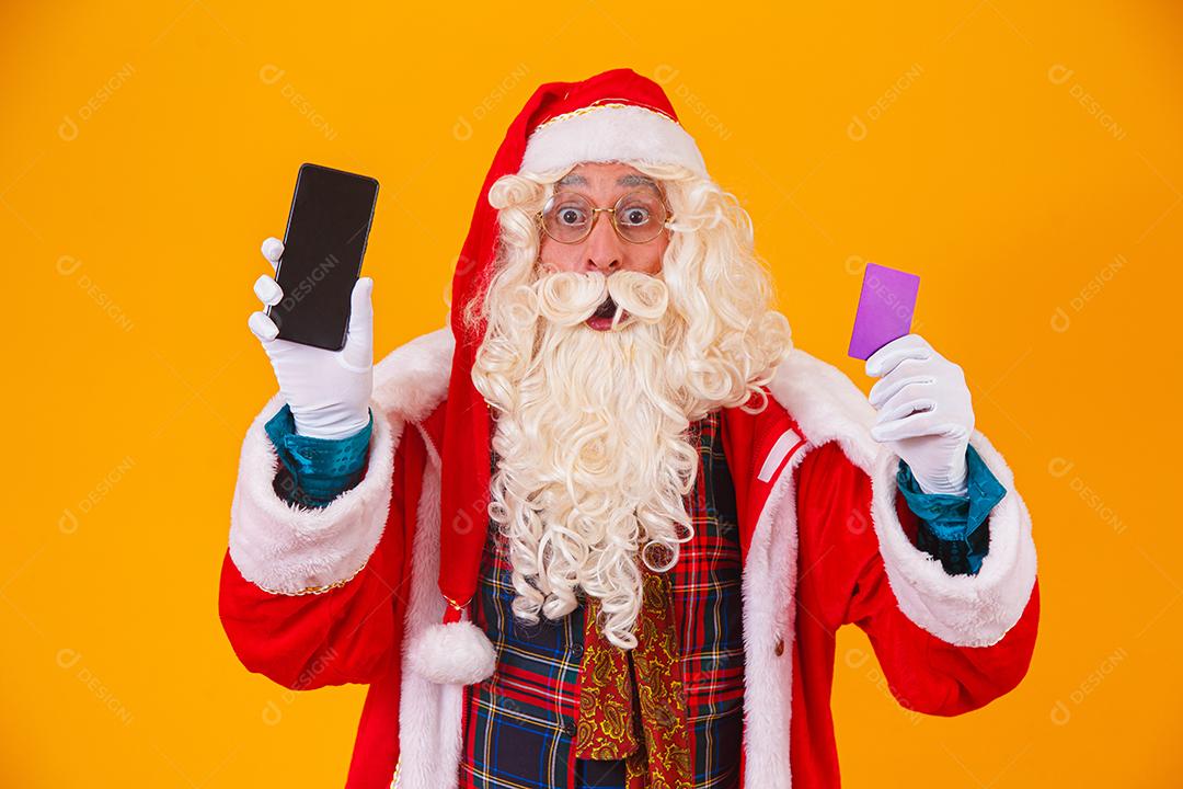 Papai Noel usando cartão de crédito para pagar compras na internet