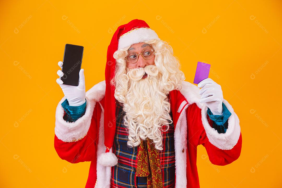 Papai Noel usando cartão de crédito para pagar compras na internet