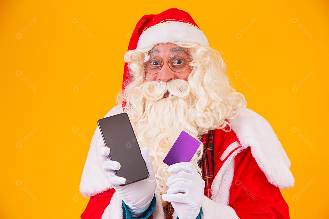 Papai Noel usando cartão de crédito para pagar compras na internet