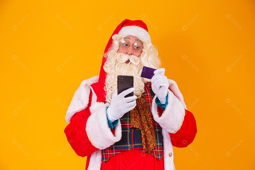 Papai Noel usando cartão de crédito para pagar compras na internet