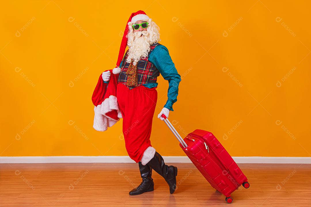 Papai Noel com sua mala. Conceito de viagens de ano novo. Papai Noel no aeroporto.