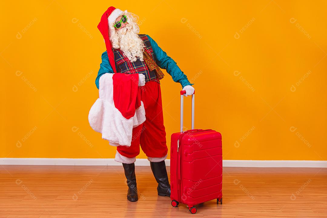Papai Noel com sua mala. Conceito de viagens de ano novo. Papai Noel no aeroporto.