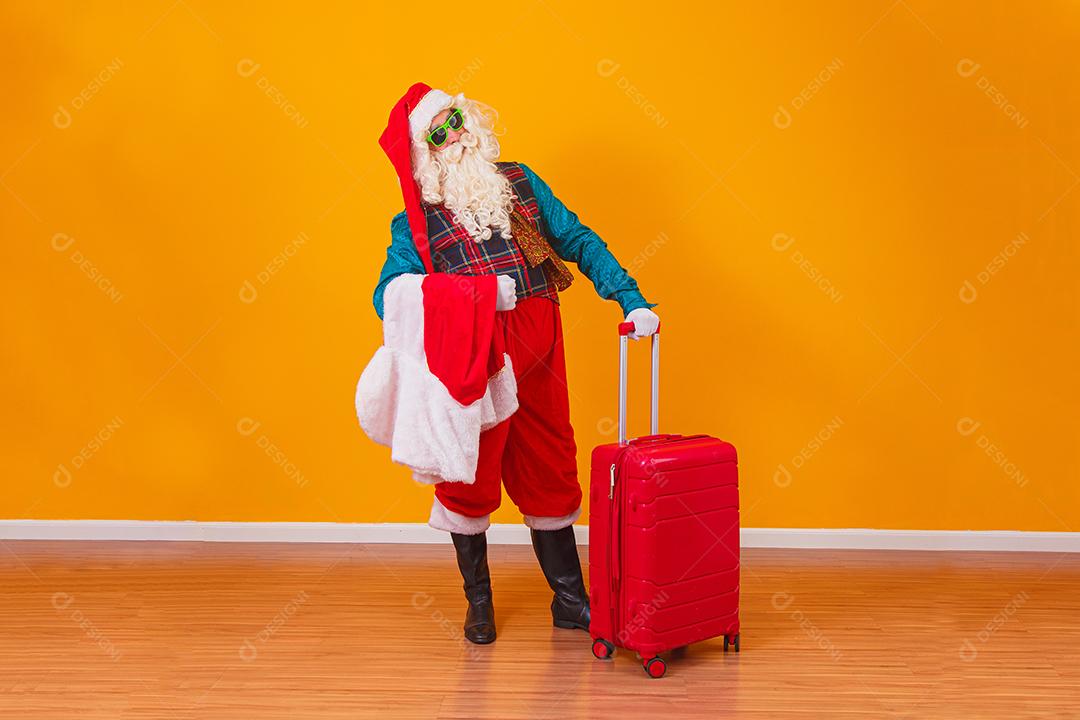 Papai Noel com sua mala. Conceito de viagens de ano novo. Papai Noel no aeroporto.