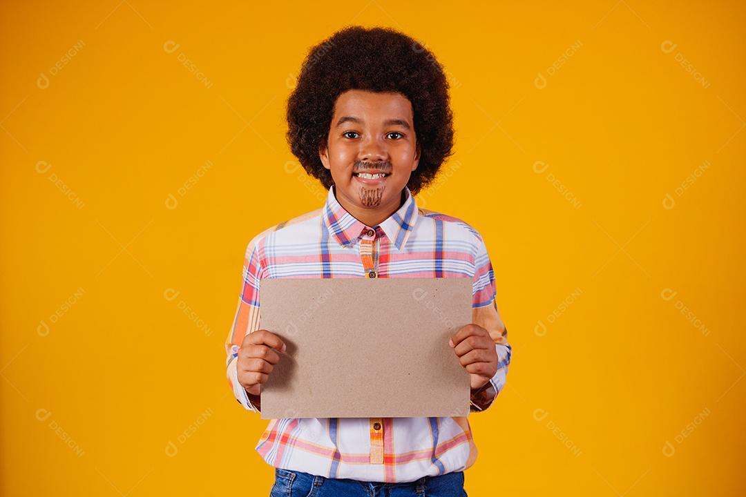 Retrato de um menino afro vestindo roupas típicas para a Festa Junina