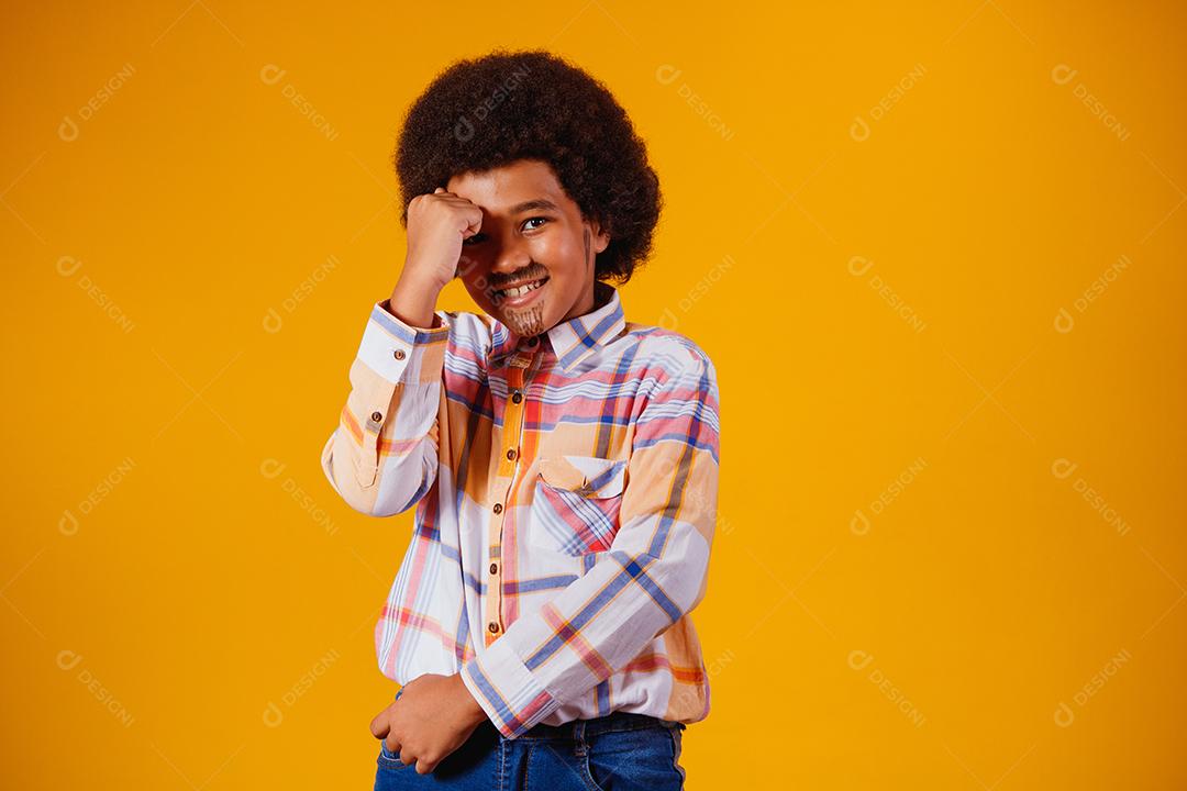 Retrato de um menino afro vestindo roupas típicas para a Festa Junina