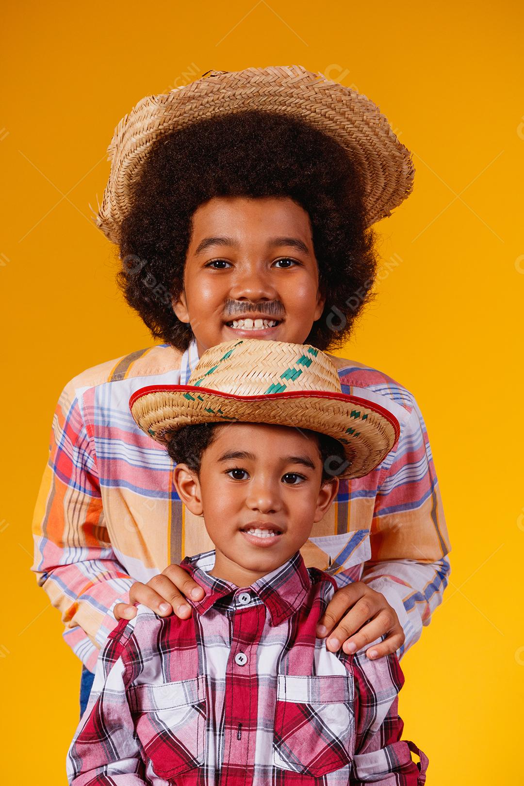 Irmãos afro vestidos com roupas de festa junina