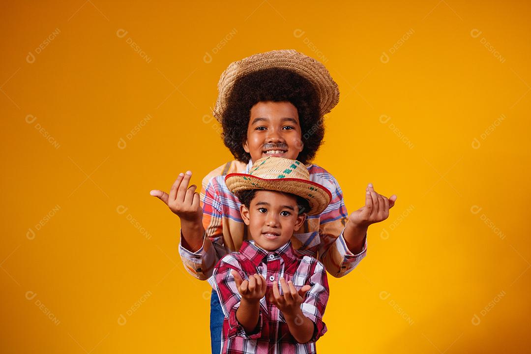Irmãos afro vestidos com roupas de festa junina