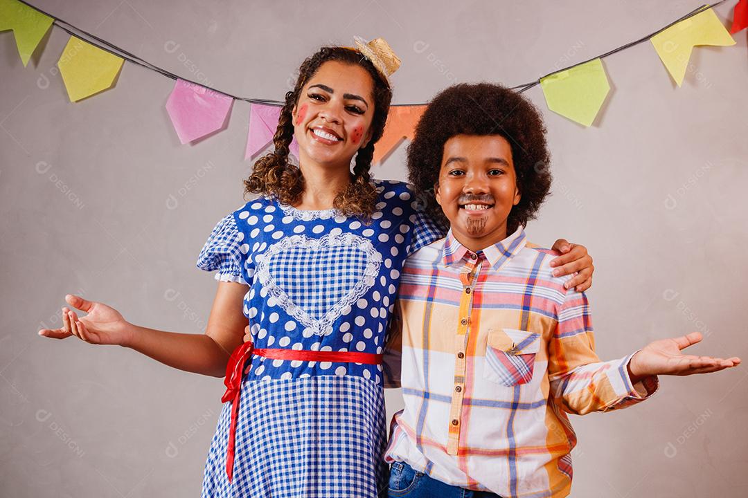 Mulher adulta e crianças vestidas para festa junina