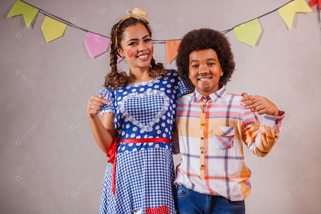 Mulher adulta e crianças vestidas para festa junina