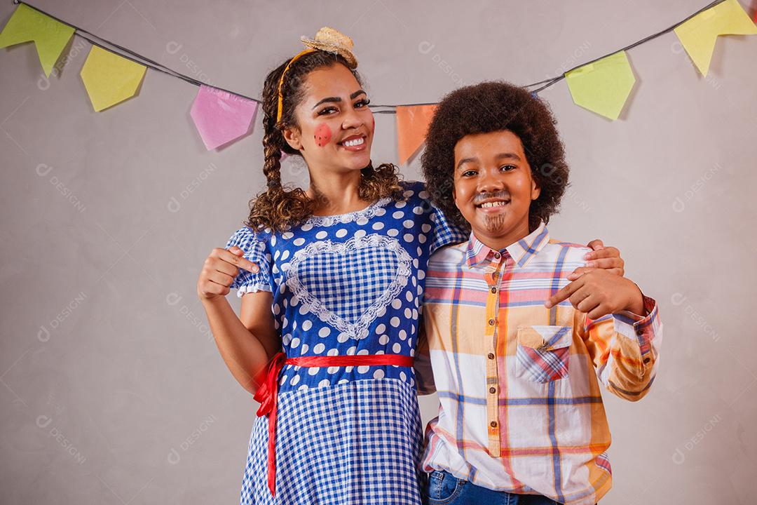 Mulher adulta e crianças vestidas para festa junina