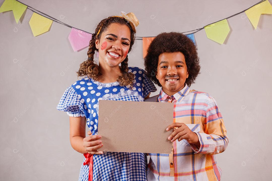 Mulher adulta e crianças vestidas para festa junina