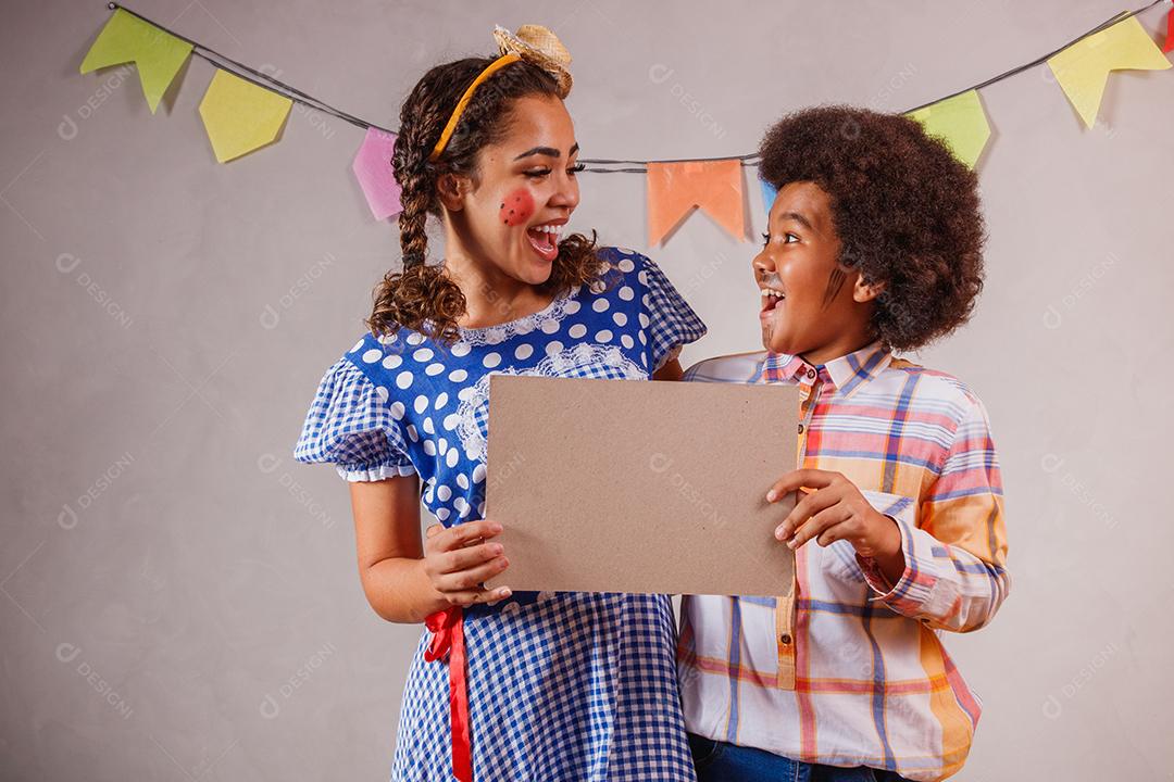 Mulher adulta e crianças vestidas para festa junina