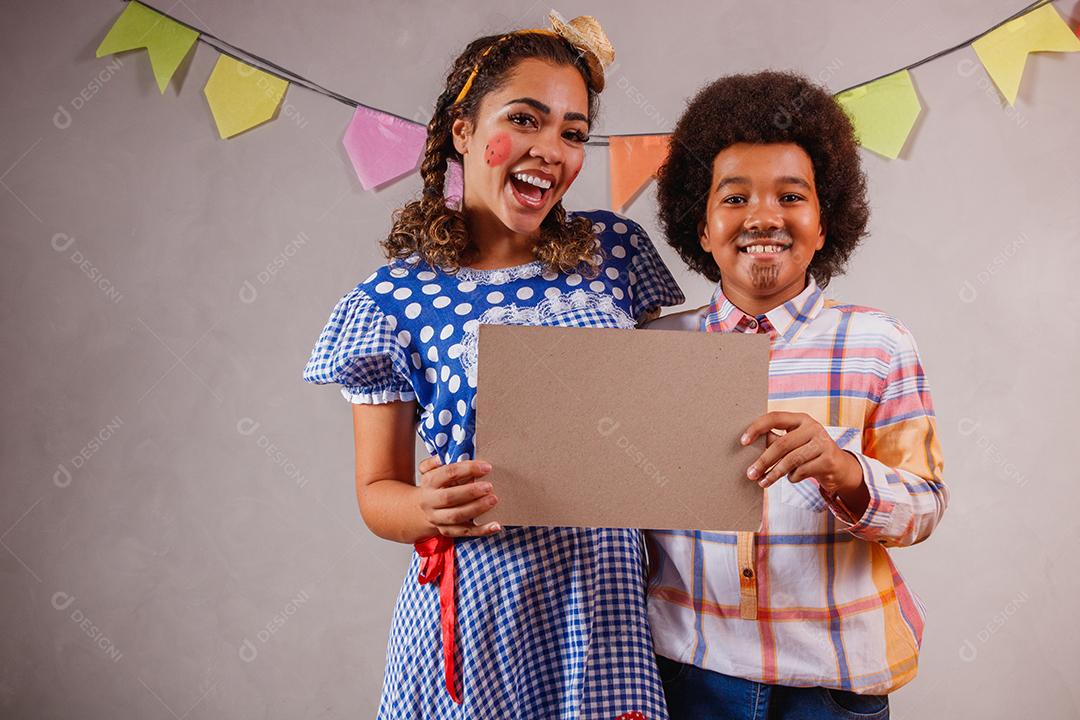 Mulher adulta e crianças vestidas para festa junina