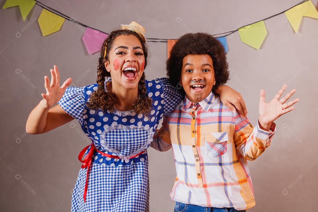 Mulher adulta e crianças vestidas para festa junina